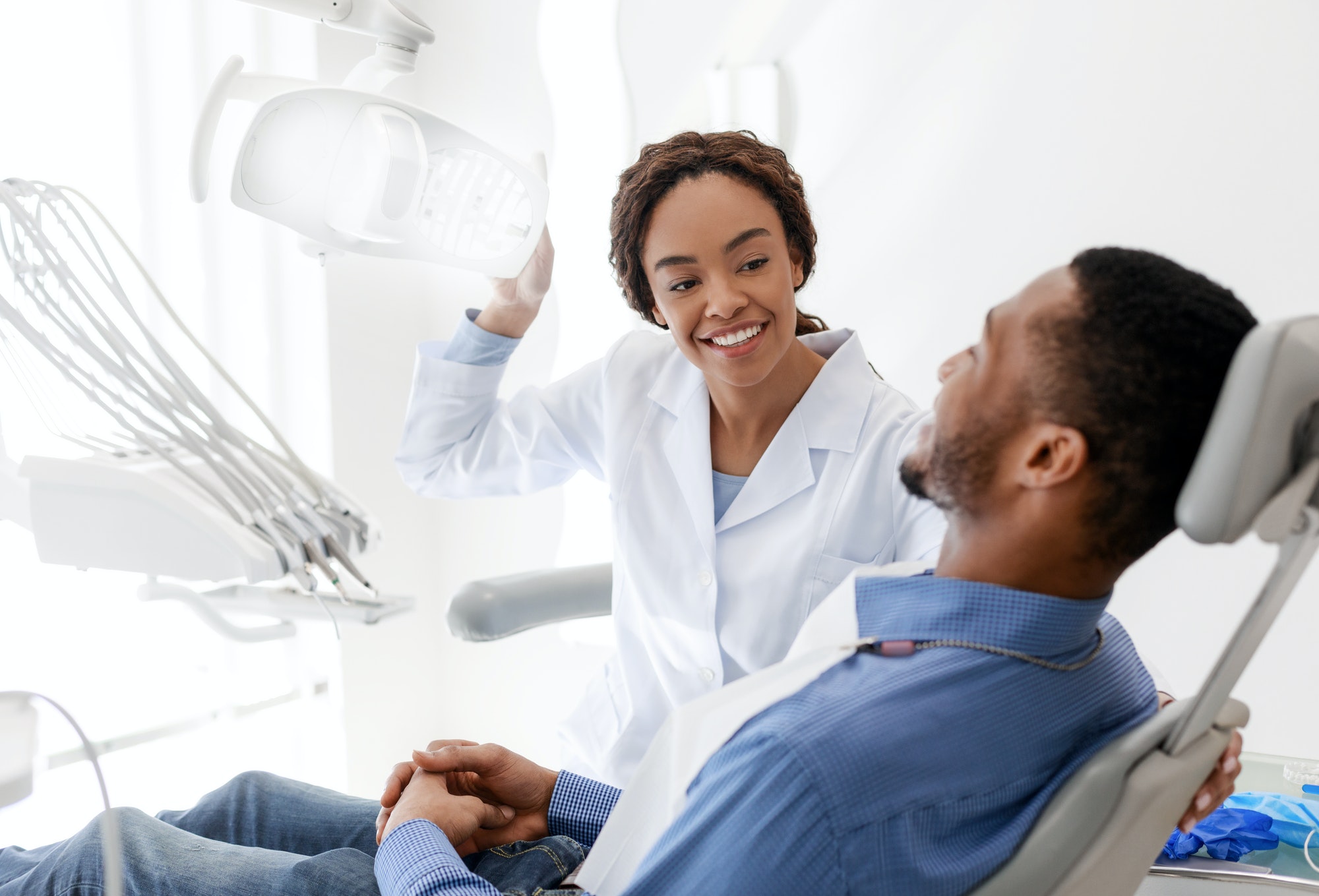Female dentist turning on lamp before treatment
